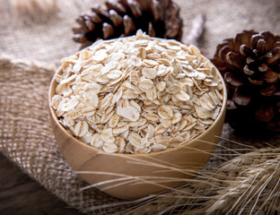 Sticker - Rolled oats (oat flakes), milk and golden wheat ears on wooden background.