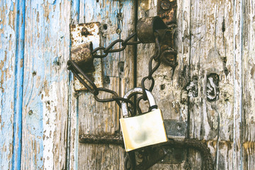 old wood door closed by golden padlock