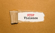 The text Stop Violence appearing behind torn brown paper