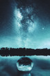 Milky way and boat on the river and the trees on the cold night reflected in the water