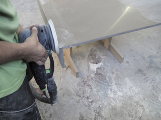 The production of acrylic worktops at a furniture factory. A worker produces acrylic countertops at the factory. A worker polishes the surface. Polishing the surface.
