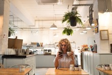 Woman Using Phone While Holding Coffee Cup