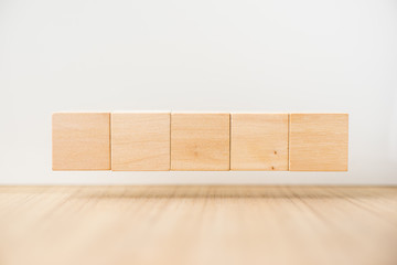Business concept - Abstract geometric real floating wooden cube on grey background and it's not 3D render, float on wood floor white background for display or montage word.