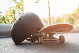 Close up skateboard and helmet, sport equipment. Summer extreme sport challenge and training background, protective sportswear in competition