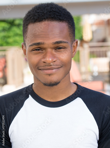 Fotografie, Obraz Closeup headshot portrait of fine young man, undergrad student, smiling, isolated on outside outdoors background