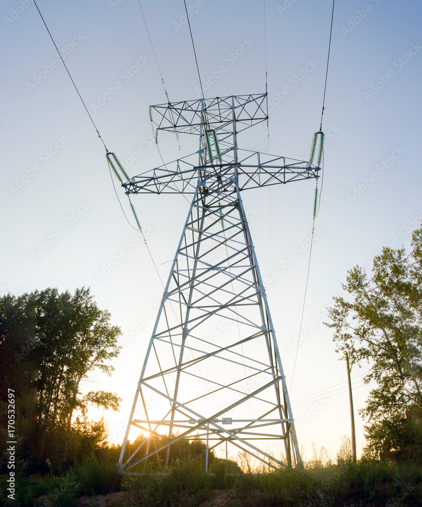 Anchor a large tower backbone transmission line is at sunset in a field ...