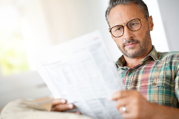 Sticker - Mature man with eyeglasses reading newspaper