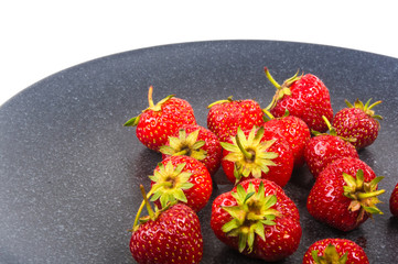 fresh ripe strawberries on black ceramic plate