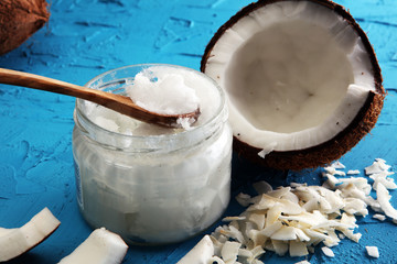 Wall Mural - coconut oil and fresh coconuts on blue background