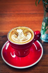 Wall Mural - Coffee cup in coffee shop,red Cup of coffee on a wooden table,cup of coffee on table in cafe,cup of cappuccino