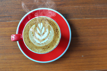 Wall Mural - red  cup of hot coffee on wooden table in coffee shop,red cup