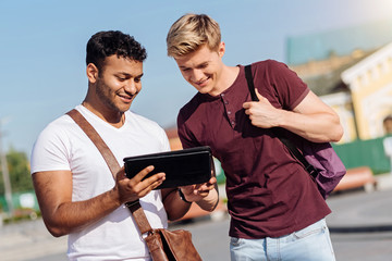 Wall Mural - Two friends looking at modern tablet