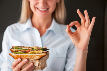 Poster - girl showing ok holding a sandwich