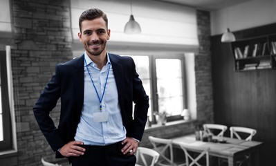 Composite image of smiling businessman with hand on hip wearing