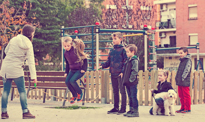 Wall Mural - Positive kids playing in jump rope game