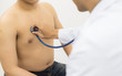 © kittipong - Professional doctor checking young man patient with a stethoscope.selective focus on hand's doctor