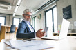 © Halfpoint - Mature businessman with laptop and smart phone.