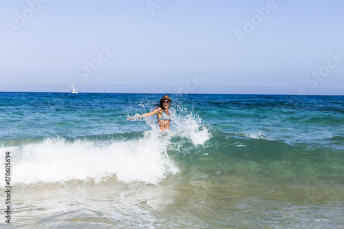 Fotografía young beautiful woman having fun in the sea and crashing waves