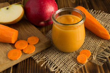 Wall Mural - Puree with apples and carrot on the wooden background