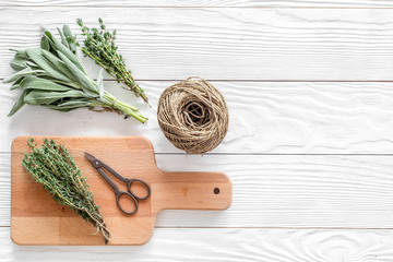 flat lay with fresh herbs and greenery for drying and making spices set on white wooden kitchen background mock-up