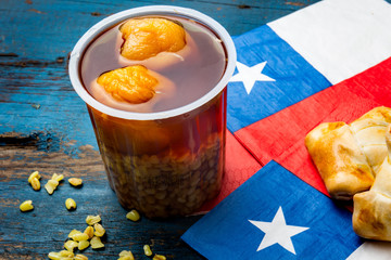 Chilean independence day concept. fiestas patrias. Chilean typical dish and drink on independence day party, 18 september. Mini empanadas, mote con huesillo, wine with toasted flor, chicha and tipical