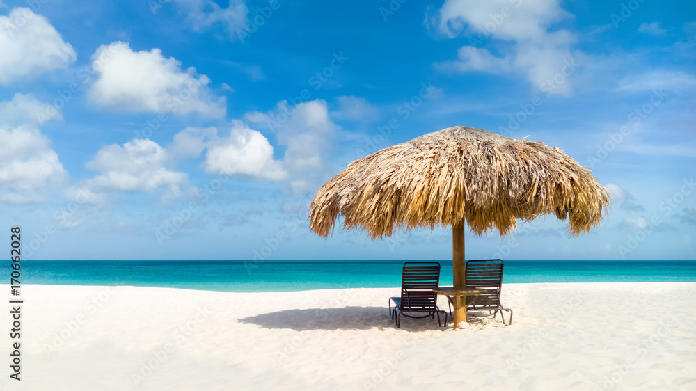Straw umbrella on Eagle Beach, Aruba on a lovely summer day - obrazy, fototapety, plakaty 