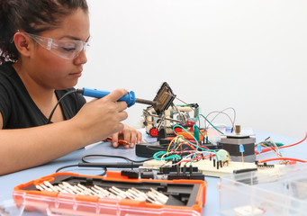 Female tech student learning how to wire a prototype circuit board