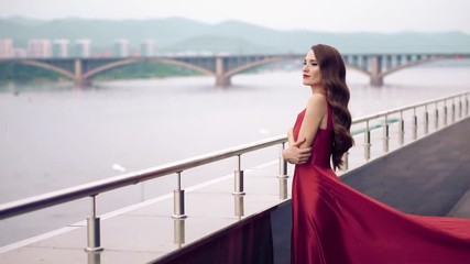 Wall Mural - Beautiful woman in red dress outdoor. City background.