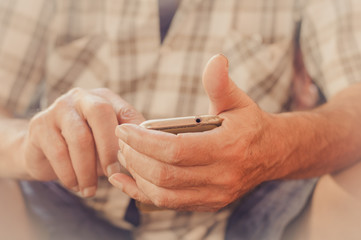 Close up of an elderly man hand using mobile smart phone