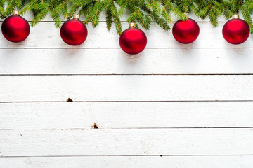 Wall Mural - Christmas background with spruce twigs and red balls on white wooden board