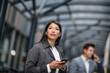 © ReeldealHD images - Businesswoman waiting for train on platform with smartphone in hand