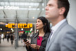 © ReeldealHD images - Commuter looking at train times at station holding smartphone