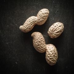 Wall Mural - Fresh peanuts in peel and shell. Dark wooden background. Vegetarian food.