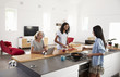 © Monkey Business - Three Female Friends Preparing Meal Together In Modern Kitchen