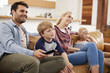 © Monkey Business - Family Sitting On Sofa In Open Plan Lounge Watching Television