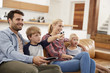 © Monkey Business - Family Sitting On Sofa In Open Plan Lounge Watching Television