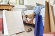 © Monkey Business - Woman Back From Shopping Trip Surrounded By Bags Lies On Bed