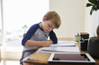 © Monkey Business - Boy Sits At Desk In Bedroom With Digital Tablet Doing Homework