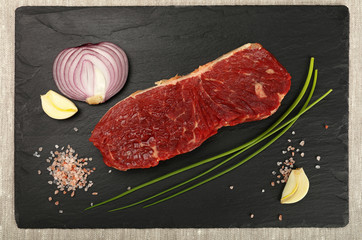 Wall Mural - Raw beef steak meat cut and spices on black board