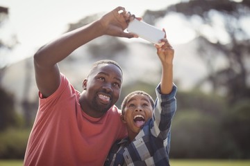 Father and son taking selfie with mobile phone