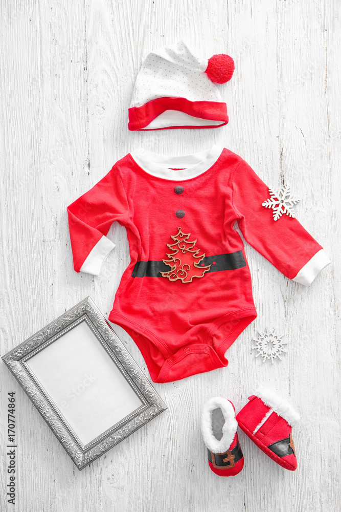 Baby Santa costume on wooden background