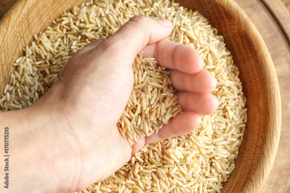 Female hand full of long grain brown rice