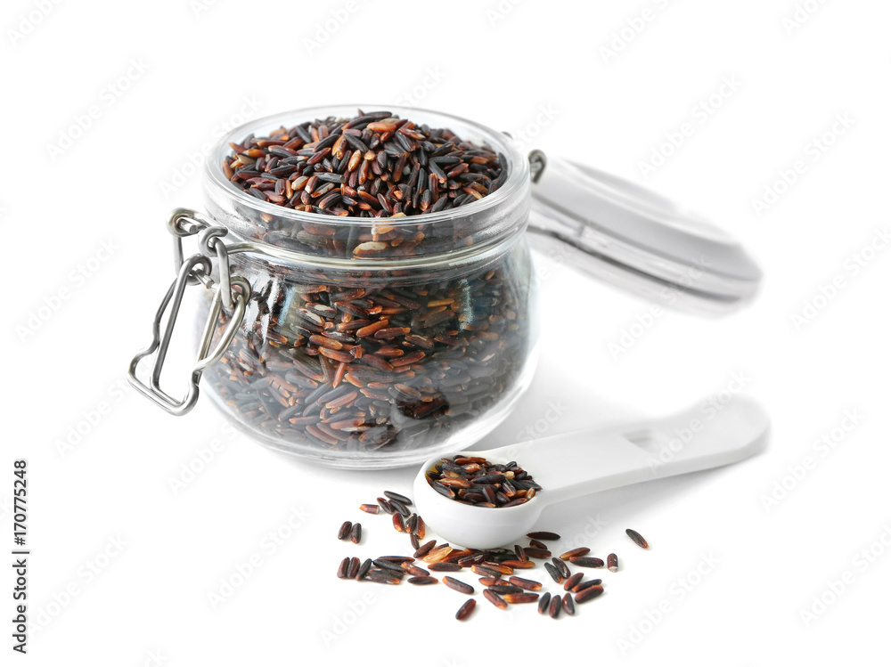 Glass jar with brown rice on white background