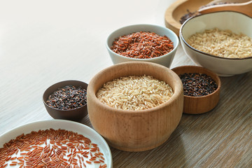 Canvas Print - Different types of rice in bowls and plate on wooden table