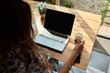 © Guille Faingold/Stocksy - Overshoulder of brunette using laptop at home