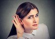 © pathdoc - Woman with a hearing loss cupping her hand behind ear to try and amplify available sound