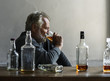 Elderly man sitting drinking whiskey alcoholic addiction bad habit