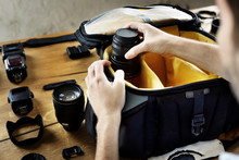 Man packing camera lens to his bag