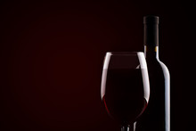 Bottle Of Red Wine And A Glass Of Red Wine On A Dark Background.