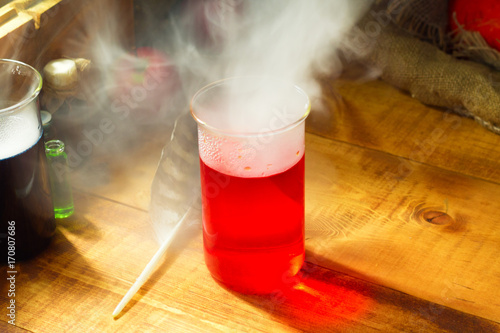 red Potion with smoke or fog on wooden background Poster